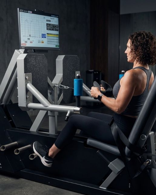 Woman using adaptive resistance machine for strength training