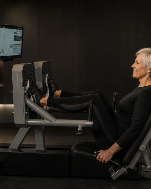Woman in her 60s performing a seated resistance exercise on an ARX machine